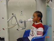 Child breathing into a machine during a lung function test