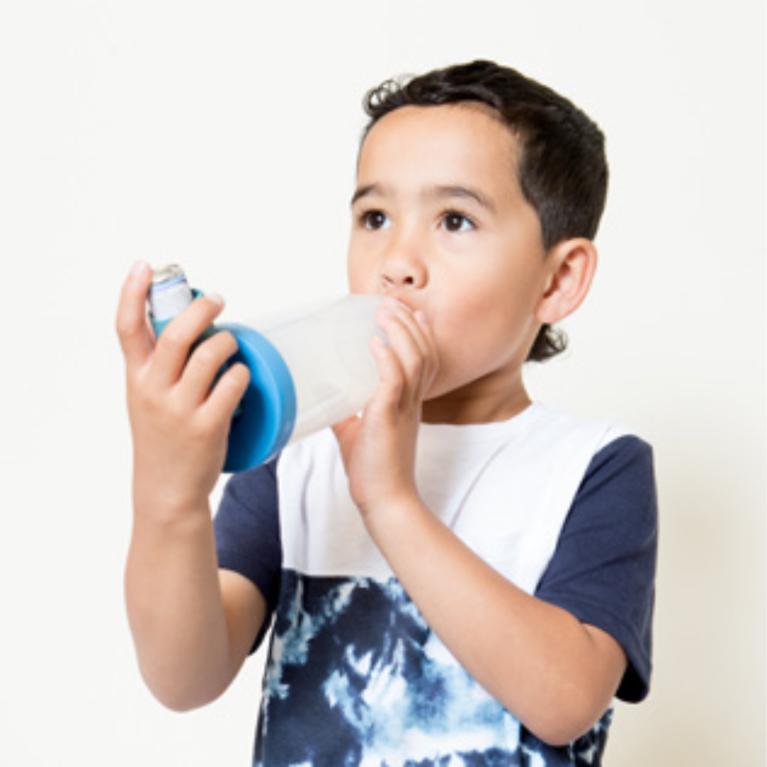 A child placing the spacer mouthpiece in their mouth.