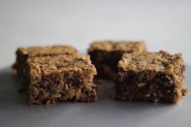 Pieces of wheat biscuit slice with a soft oat texture on a grey surface.