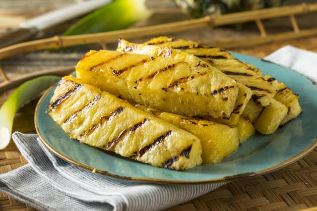 Grilled pineapple slices with char marks served on a blue plate.