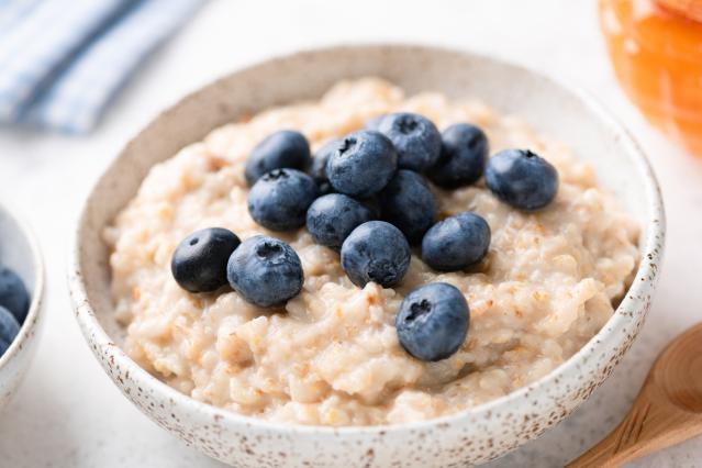 Bowl of creamy porridge topped with fresh blueberries.