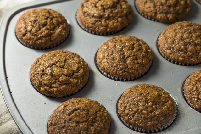 Bran, honey, and banana muffins freshly baked in a muffin tray.
