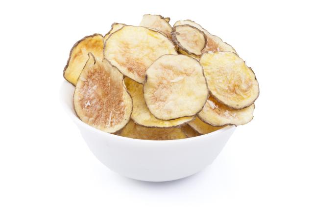 A white bowl filled with thin homemade potato chips on a plain light background.