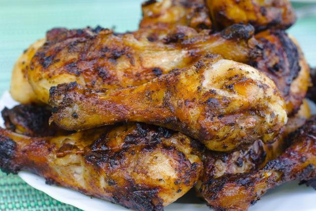 A plate piled with honey-glazed roasted chicken drumsticks with browned, crispy skin.