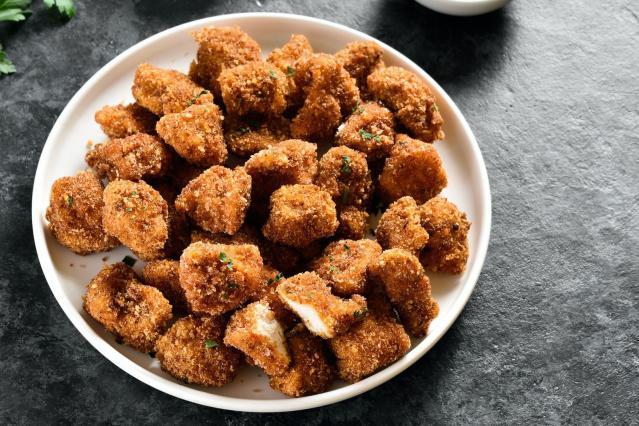 A plate of bite-sized crumbed chicken pieces with a crispy golden coating.
