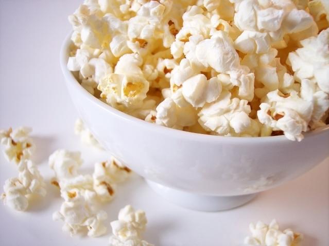 White bowl on the bench filled with popcorn