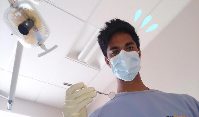 Photo of a dentist looking down towards patient
