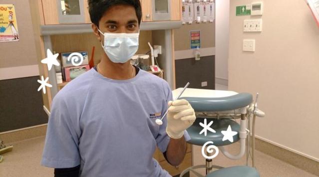 Dental therapist in a mask and gown