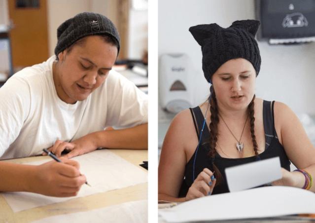 The image shows two individuals working side by side. On the left, a person in a white shirt and gray beanie is focused on drawing with a pencil. On the right, a person wearing a black cat-ear beanie and headphones is writing or sketching on a tablet.