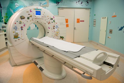 Photo of a CT scanner with stickers on it 