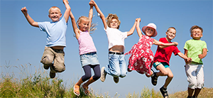 Group of young children jumping and holding hands