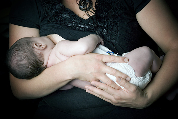 Mother breastfeeding her baby, positioned in cradle hold
