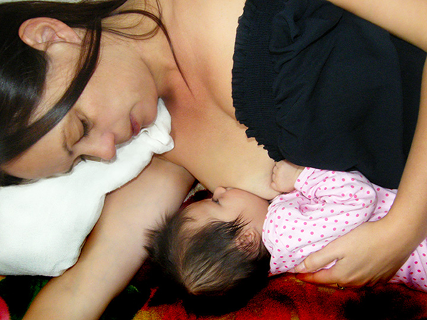 Mother breastfeeding her baby, in side-lying position
