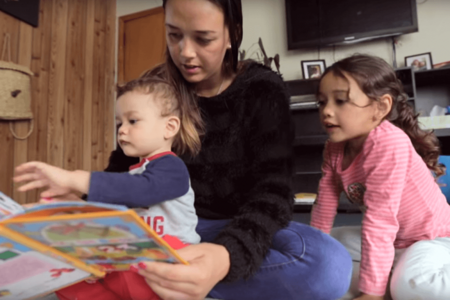 A mother reading to her 2 children