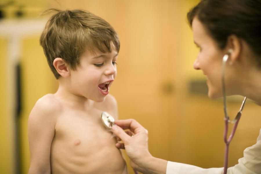 Doctor examining young boy with a stethoscope