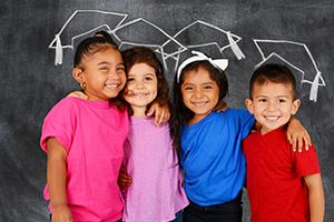 4 children standing in front of a blackboard
