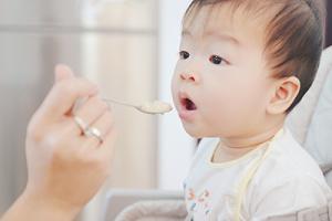 Child being fed in high chair small