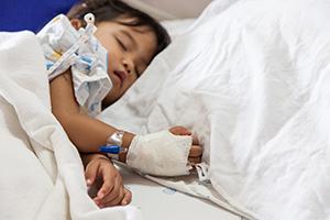Sick child lying in hospital bed