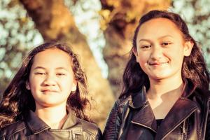 Portrait of two young sisters taken outdoors in a park